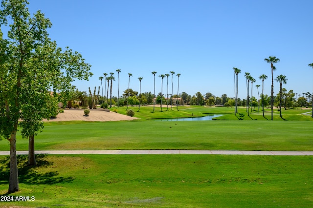 surrounding community featuring a water view and a lawn