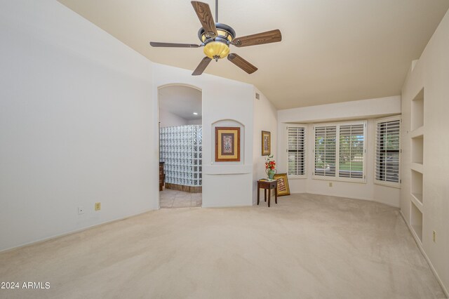 unfurnished room featuring light colored carpet, ceiling fan, and vaulted ceiling