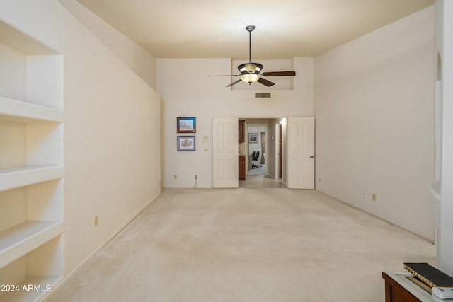 carpeted empty room featuring built in features and ceiling fan