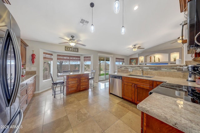 kitchen with sink, light tile patterned floors, appliances with stainless steel finishes, pendant lighting, and light stone countertops