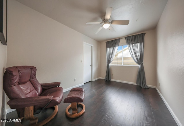 sitting room with dark wood-type flooring and ceiling fan