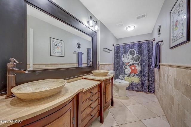 bathroom featuring tile patterned floors, toilet, a shower with curtain, tile walls, and vanity