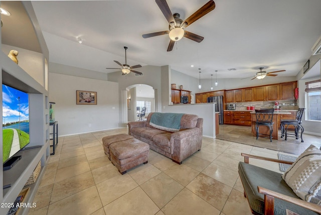 living room with light tile patterned flooring, vaulted ceiling, a healthy amount of sunlight, and ceiling fan