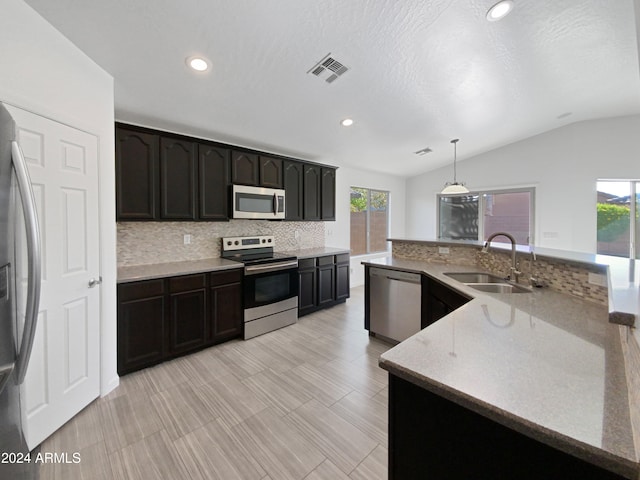 kitchen featuring stainless steel appliances, lofted ceiling, sink, and plenty of natural light