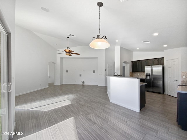 kitchen featuring tasteful backsplash, ceiling fan, dark brown cabinetry, lofted ceiling, and stainless steel refrigerator with ice dispenser