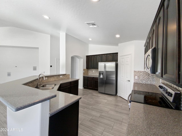 kitchen featuring sink, decorative backsplash, stainless steel appliances, and vaulted ceiling