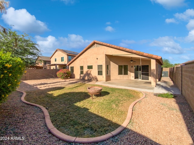 back of property with a patio area, a lawn, and ceiling fan