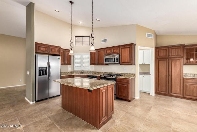 kitchen with appliances with stainless steel finishes, visible vents, a sink, and a kitchen island