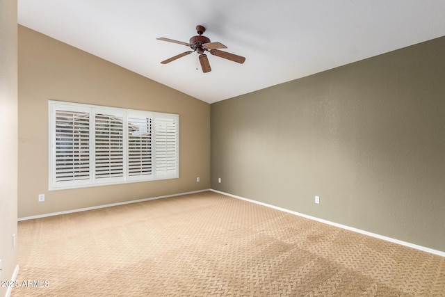 carpeted spare room featuring lofted ceiling, ceiling fan, and baseboards