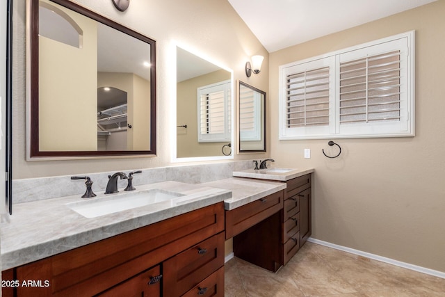 full bath with double vanity, tile patterned flooring, baseboards, and a sink