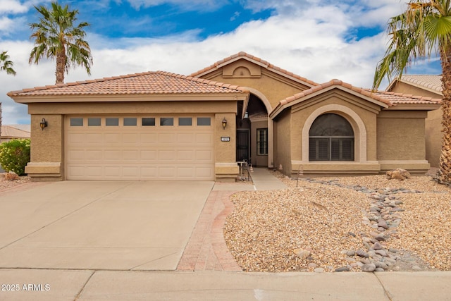 view of front of house featuring a garage, concrete driveway, a tile roof, and stucco siding