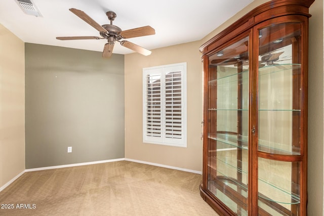 empty room with a ceiling fan, carpet, visible vents, and baseboards