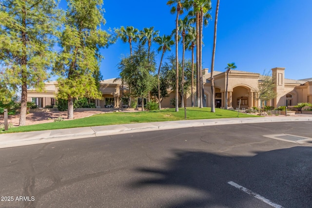 southwest-style home with a front lawn and stucco siding