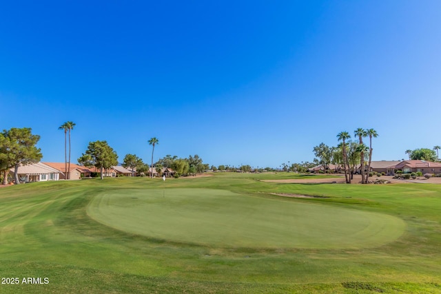 view of home's community with view of golf course and a yard