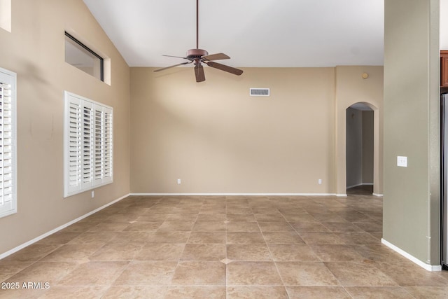 spare room with arched walkways, visible vents, ceiling fan, and baseboards