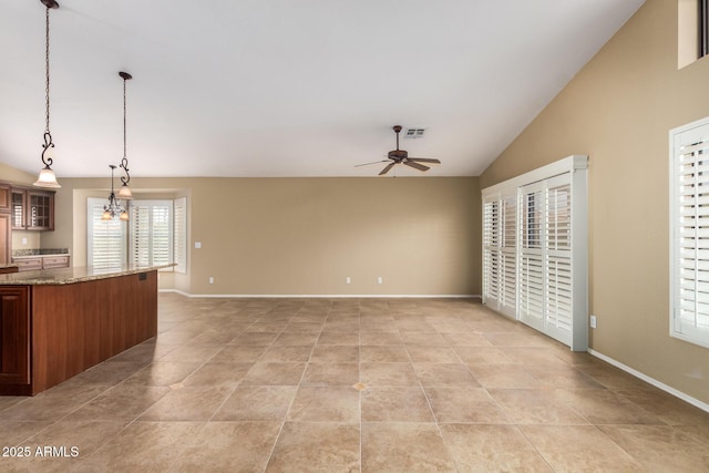 kitchen featuring decorative light fixtures, visible vents, glass insert cabinets, vaulted ceiling, and ceiling fan with notable chandelier