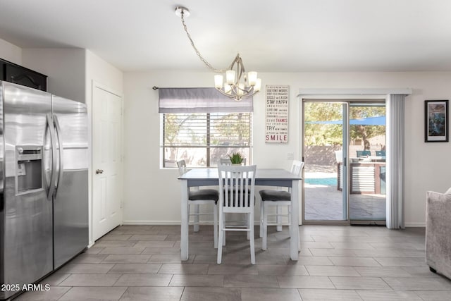 dining room with plenty of natural light, baseboards, and an inviting chandelier