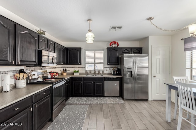 kitchen with appliances with stainless steel finishes, plenty of natural light, visible vents, and a sink