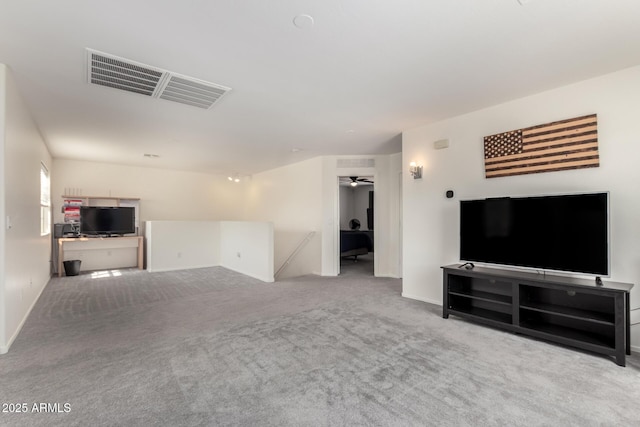 living room with baseboards, carpet, visible vents, and a ceiling fan