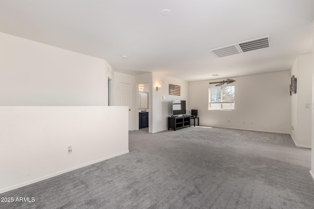 unfurnished living room with light carpet, visible vents, and baseboards