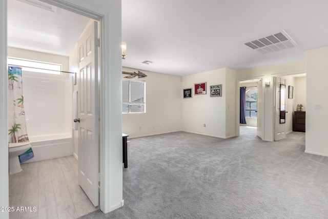 empty room with baseboards, visible vents, and carpet flooring