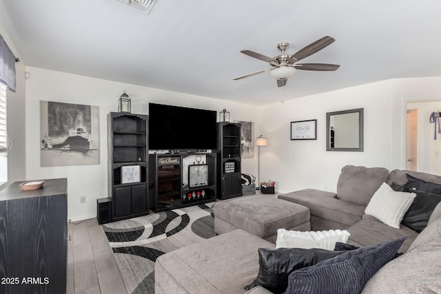 living area featuring visible vents, ceiling fan, and wood finished floors