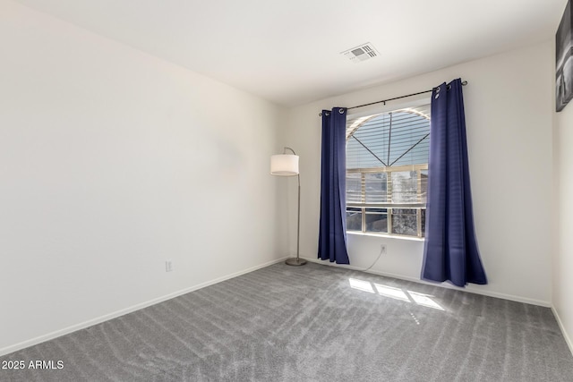 carpeted spare room with visible vents and baseboards