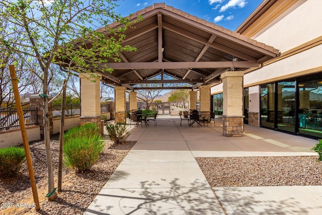 view of home's community featuring outdoor dining space, fence, a patio, and a gazebo