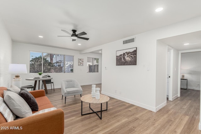 living room featuring ceiling fan and light hardwood / wood-style floors