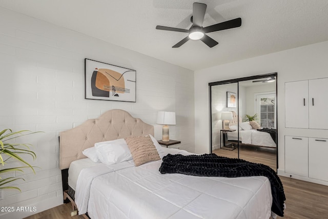 bedroom with hardwood / wood-style flooring, a textured ceiling, ceiling fan, and a closet