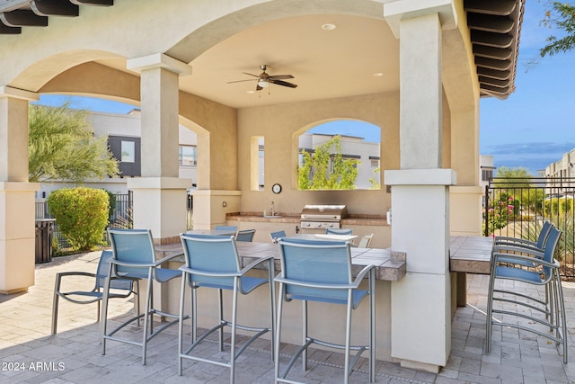 view of patio / terrace with ceiling fan, an outdoor wet bar, and a grill