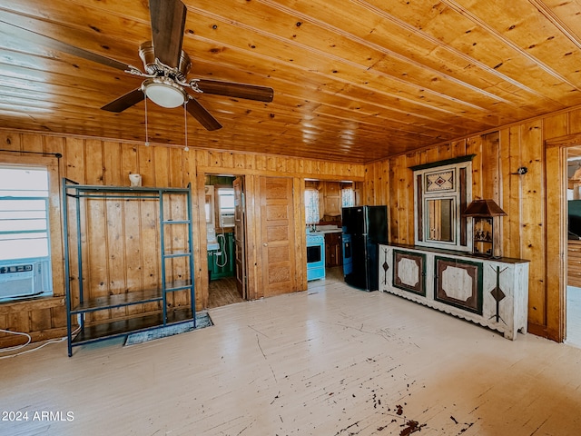 interior space featuring wooden walls, ceiling fan, and plenty of natural light