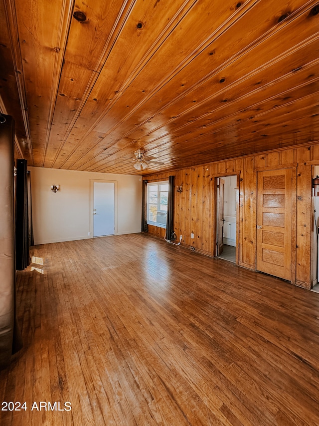 interior space with wood ceiling, wooden walls, ceiling fan, and hardwood / wood-style flooring