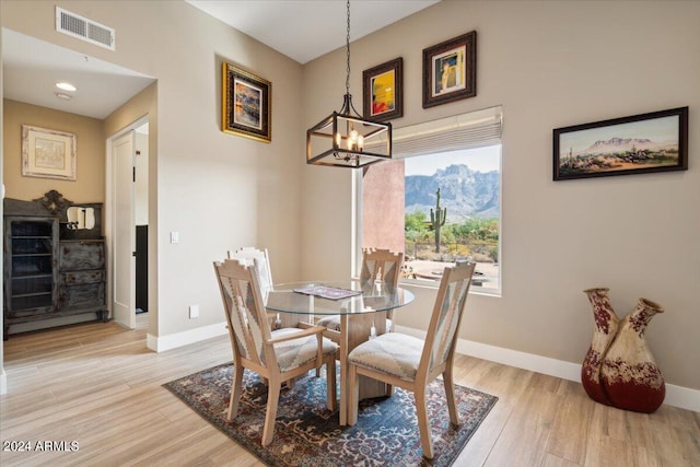 dining area featuring an inviting chandelier and light hardwood / wood-style flooring