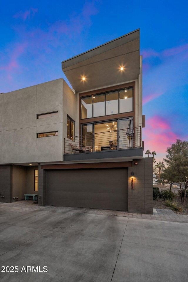 contemporary house featuring a garage and a balcony