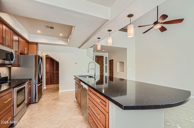 kitchen featuring sink, hanging light fixtures, a center island with sink, appliances with stainless steel finishes, and light tile patterned floors