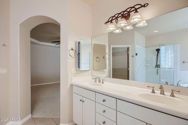 bathroom featuring tile patterned flooring, vanity, and a shower with shower door