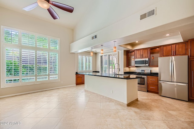 kitchen with stainless steel appliances, a wealth of natural light, a kitchen island with sink, and sink