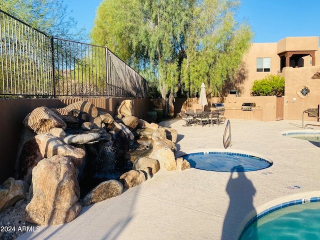 view of pool featuring a patio area and grilling area