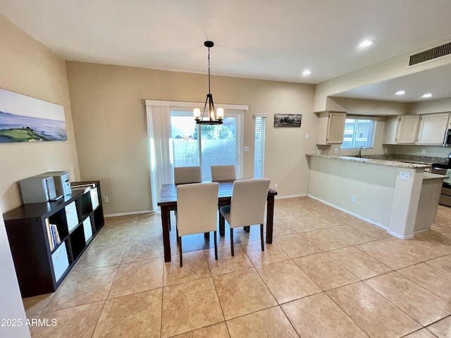 dining space with light tile patterned floors, a notable chandelier, and baseboards