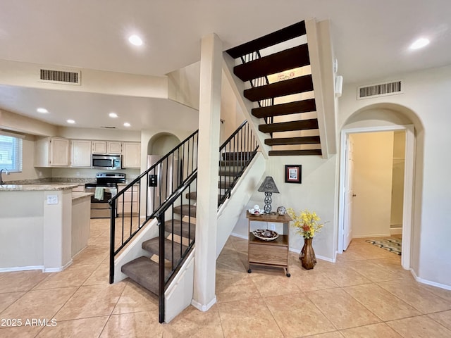 stairway with tile patterned flooring, visible vents, and recessed lighting