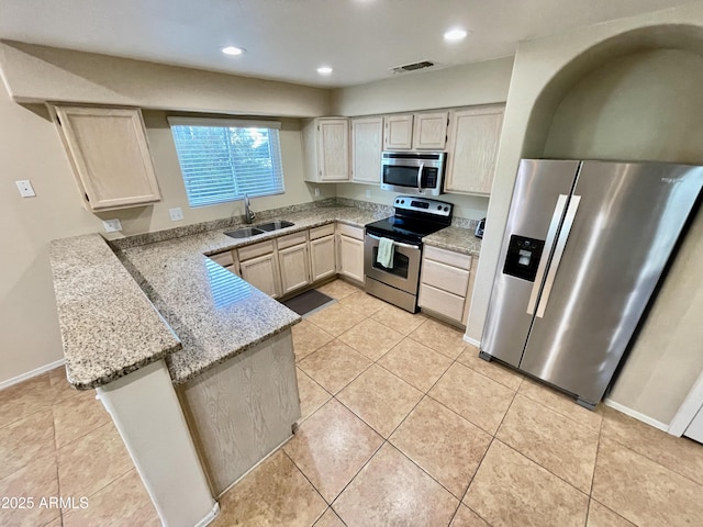 kitchen featuring visible vents, light tile patterned floors, a peninsula, stainless steel appliances, and a sink