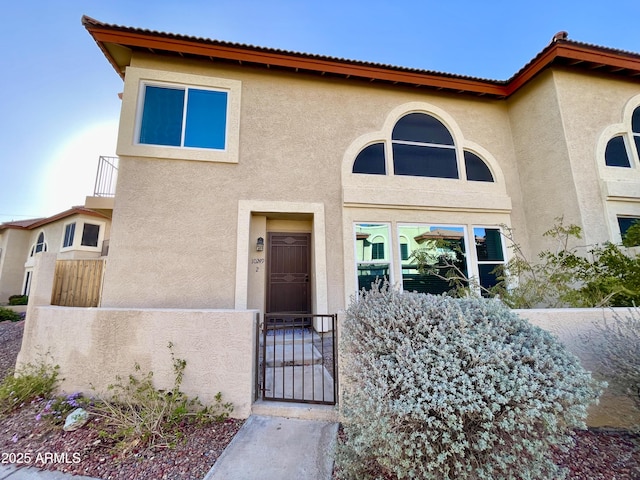 view of front of house with a gate, a fenced front yard, and stucco siding