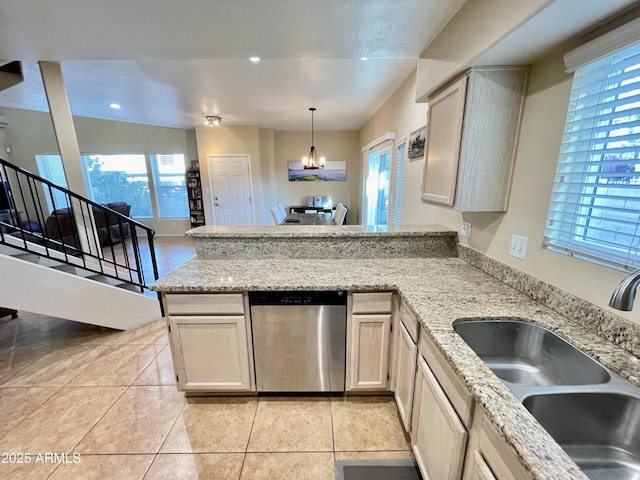 kitchen with a chandelier, dishwasher, light stone counters, a peninsula, and a sink