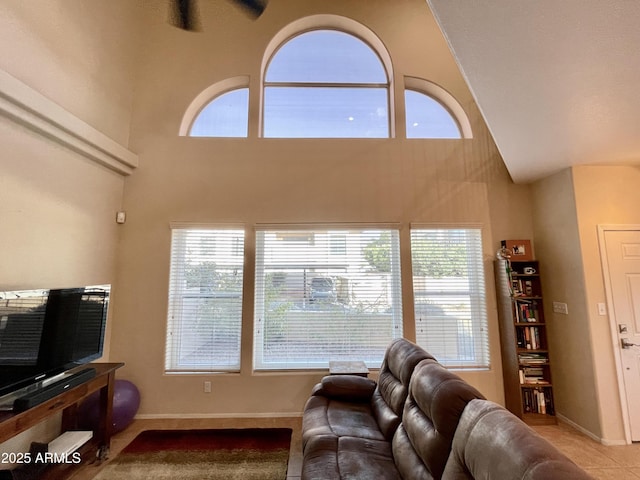 living room with baseboards and a towering ceiling