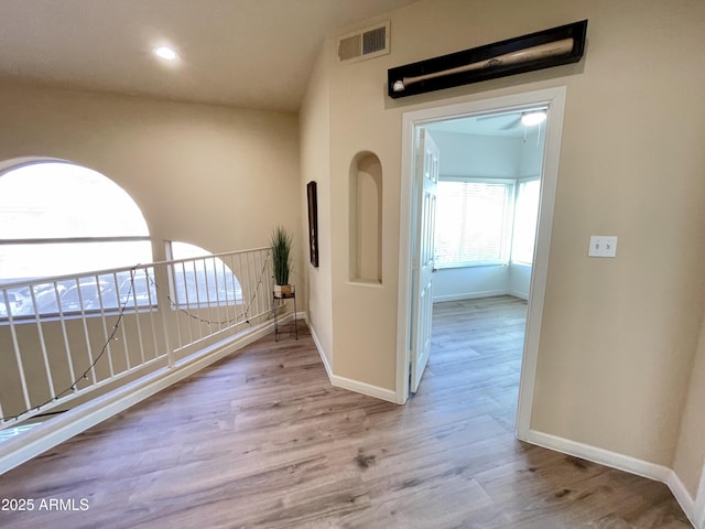 hallway with recessed lighting, visible vents, baseboards, and wood finished floors