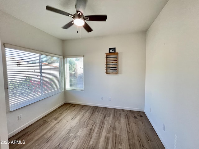 empty room featuring baseboards, ceiling fan, and wood finished floors