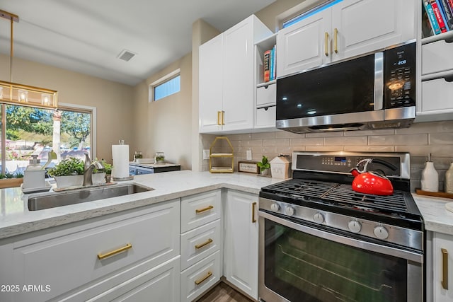 kitchen featuring light stone counters, sink, white cabinets, and appliances with stainless steel finishes