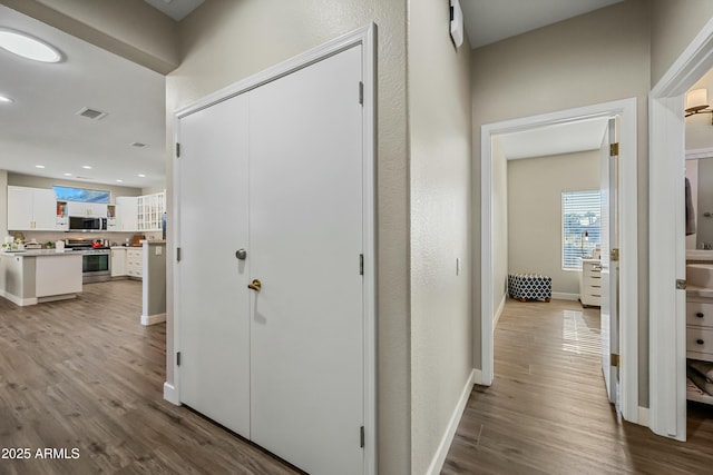 hallway with light hardwood / wood-style floors