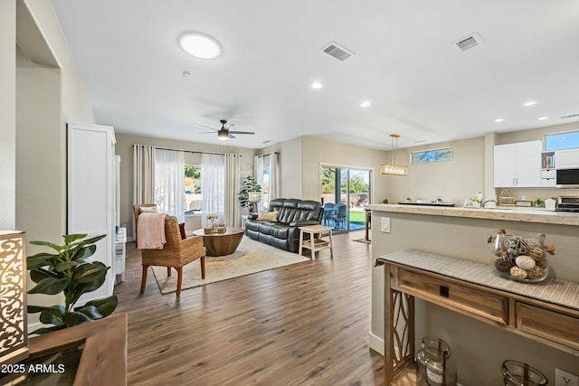 living room featuring dark wood-type flooring and ceiling fan